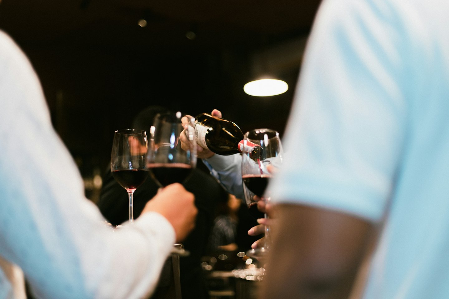 Un sommelier versa vino rosso in un calice durante un evento.
