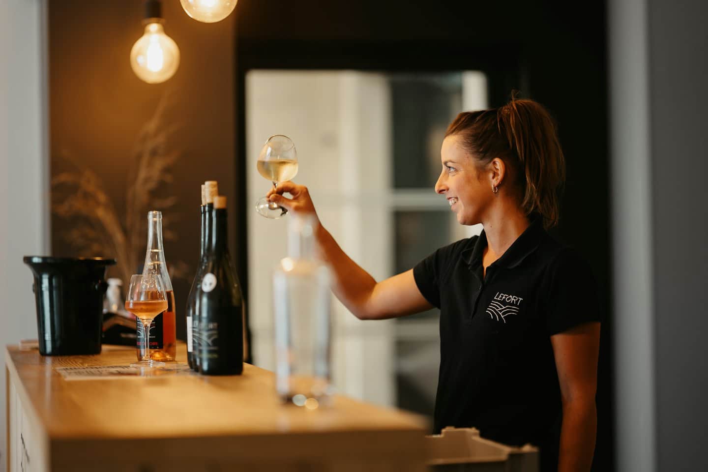 Un membro dello staff della cantina esamina un bicchiere di vino bianco.